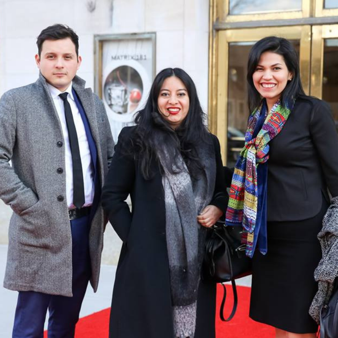 Three people standing on red carpet